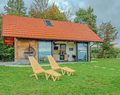 two chairs sitting in the grass in front of a house at Holiday home in Trebelno - Dolenjska & Bela krajina (Unter- & Weißkrain) 54728 in Trebelno