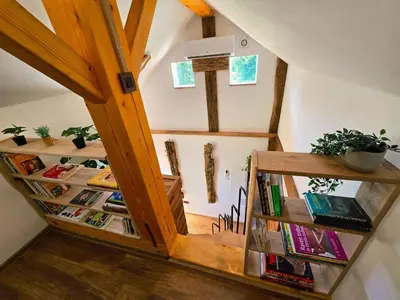an attic room with bookshelves and a staircase at Holiday home in Trebelno - Dolenjska & Bela krajina (Unter- & Weißkrain) 54728 in Trebelno