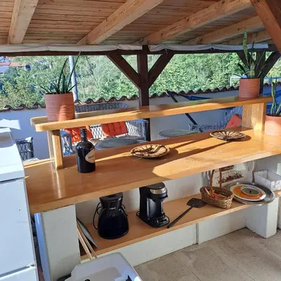 a wooden shelf in a kitchen with plants on it at Hiša Gadiča in Tolmin