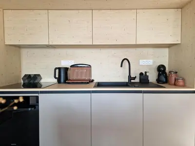 a kitchen with white cabinets and a sink at House B in Dekani