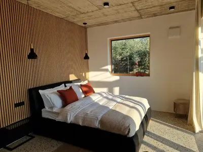 a bedroom with a bed with a striped wall at House B in Dekani