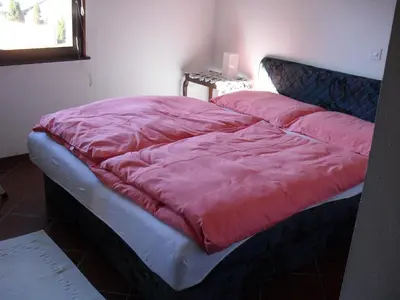 a bed with a red blanket on top of it at Holiday House Bohinj in Bohinj