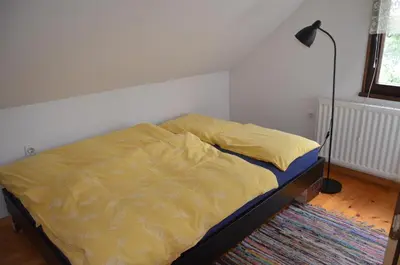 a bed with a yellow comforter in a bedroom at Holiday House Bohinj in Bohinj