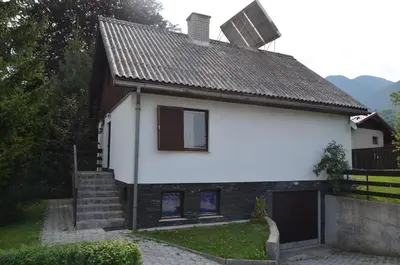 a white house with a brown roof at Holiday House Bohinj in Bohinj
