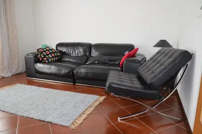 a black leather couch and chair in a living room at Holiday House Bohinj in Bohinj