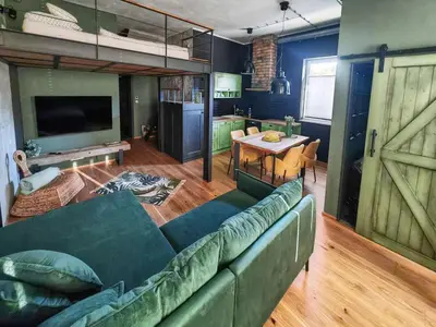 a living room with a green couch and a table at Apartmaji Remsova in Maribor