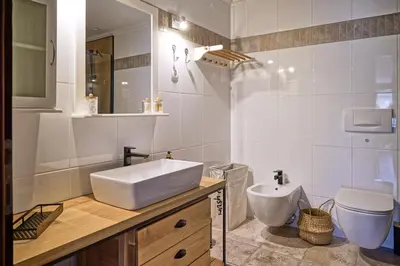 a white bathroom with a sink and a toilet at Apartmaji Remsova in Maribor