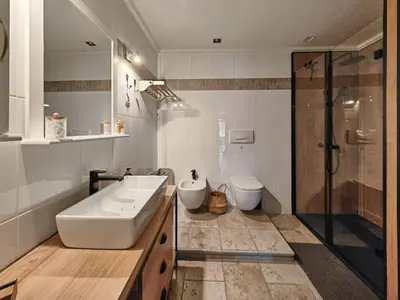 a bathroom with a sink and a shower and a toilet at Apartmaji Remsova in Maribor