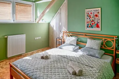 a bedroom with a large bed with two shoes on it at Apartmaji Remsova in Maribor