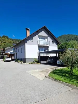 a large white house with a parking lot at Apartma LONČAR in Horjul