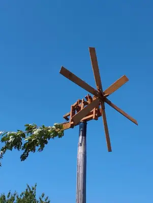 a wooden windmill against a blue sky at Parzival relax Apartment in Žetale