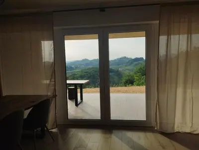 a sliding glass door with a view of a table at Parzival relax Apartment in Žetale