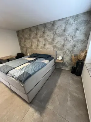 a bedroom with a bed and a concrete wall at Korantov Hram