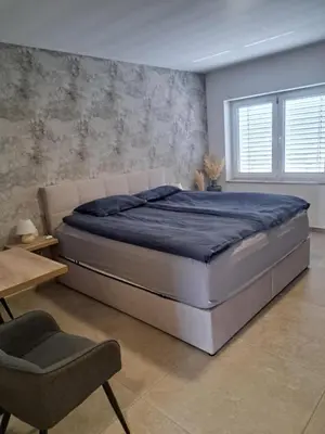 a bedroom with a large bed and a chair at Korantov Hram