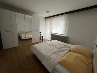 a bedroom with a white bed and a mirror at Gostišče Krpan in Grosuplje