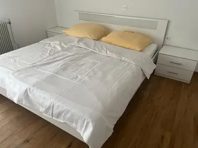 a bed with white sheets and two pillows on it at Gostišče Krpan in Grosuplje