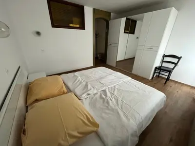 a bedroom with a bed and a chair in it at Gostišče Krpan in Grosuplje