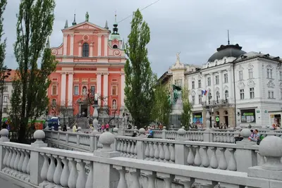 a white fence in front of a city with buildings at Apartment Bright & Light in Ljubljana