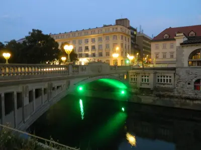 a bridge over a river in a city at night at Apartment Bright & Light in Ljubljana