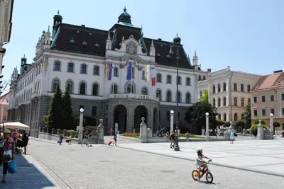 a child riding a bike in front of a building at Apartment Bright & Light in Ljubljana