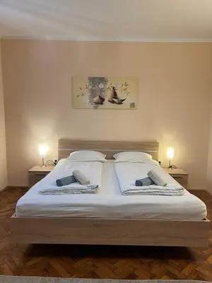 a bedroom with a large bed with two lamps on it at Apartment Bright & Light in Ljubljana