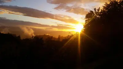 a sunset with the sun in the sky at Turizem Pavlin Apartments in Šenturska Gora