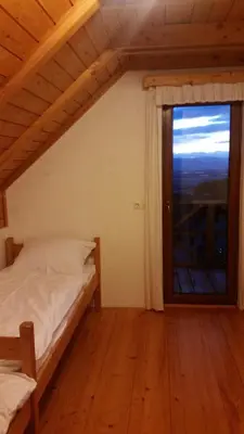 a bedroom with a bed and a large window at Turizem Pavlin Apartments in Šenturska Gora