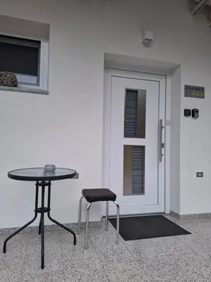 a table and two chairs in front of a door at Prenočišča Dany APARTMA 1 in Dravograd