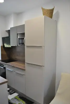 a kitchen with white cabinets and a microwave at Prenočišča Dany APARTMA 1 in Dravograd