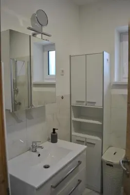 a white bathroom with a sink and a mirror at Prenočišča Dany APARTMA 1 in Dravograd
