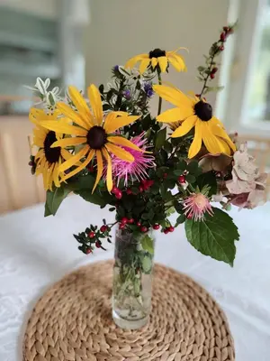 a vase filled with yellow flowers on a table at Apartment Green Oasis in Bled
