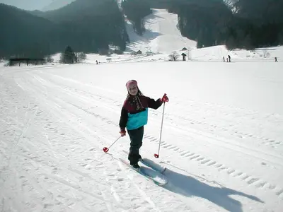 a woman is standing on skis in the snow at Apartment Jakelj in Kranjska Gora