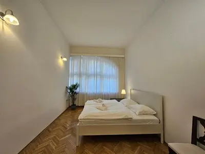 a bedroom with a white bed with a window at Historic Townhouse Apartment Tina by City Hall in Ljubljana