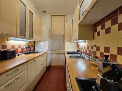 a kitchen with white cabinets and a sink at Historic Townhouse Apartment Tina by City Hall in Ljubljana
