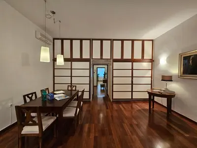 a dining room with a table and chairs and a room with a door at Historic Townhouse Apartment Tina by City Hall in Ljubljana