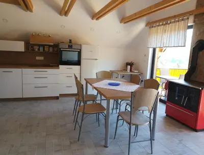 a kitchen with a table and chairs in a room at Apartma Jezero in Grahovo