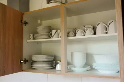 a cabinet filled with plates and cups and dishes at Turistična Kmetija Čebelji Gradič in Rogašovci