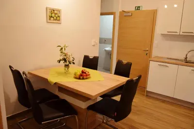 a dining room table with a bowl of fruit on it at Turistična Kmetija Čebelji Gradič in Rogašovci
