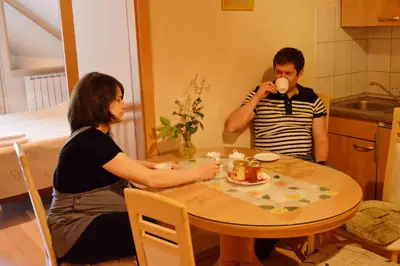 a man and woman sitting at a table drinking coffee at Turistična Kmetija Čebelji Gradič in Rogašovci