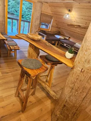 a log cabin with a table and two stools at Cozy house Dalija in Radovljica