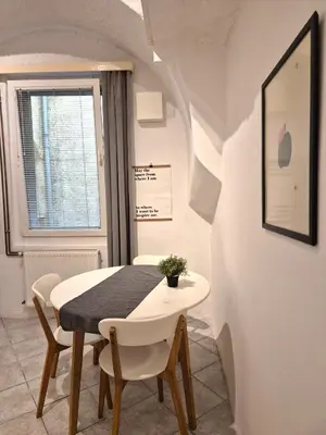 a dining room with a white table and chairs at Walter Apartment City Center in Ljubljana