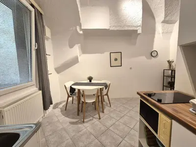 a kitchen with a table and chairs in a room at Walter Apartment City Center in Ljubljana