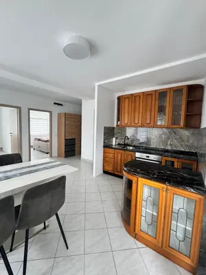 a kitchen with wooden cabinets and a counter top at Apartments Klavdija Celje in Celje