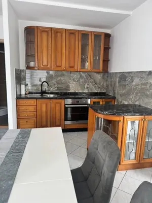 a kitchen with wooden cabinets and a sink at Apartments Klavdija Celje in Celje