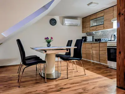 a kitchen with a table and black chairs at Gostilna The RIVER in Dravograd