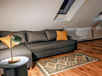 a living room with a couch and a lamp at Gostilna The RIVER in Dravograd