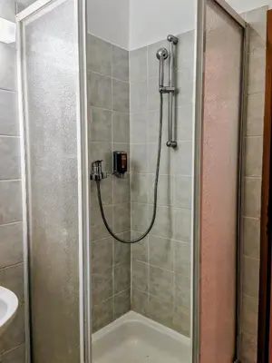 a shower with a hose in a bathroom at Gostilna The RIVER in Dravograd
