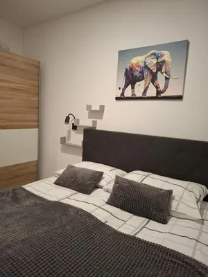a bedroom with a bed with a painting of an elephant at Prenočišča Dany APARTMA 2 in Dravograd