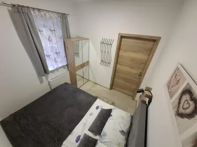 a bedroom with a bed and a window and a door at Prenočišča Dany APARTMA 2 in Dravograd