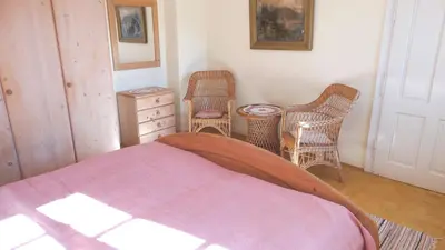 a bedroom with a bed and two chairs and a table at Marta's House in Bled